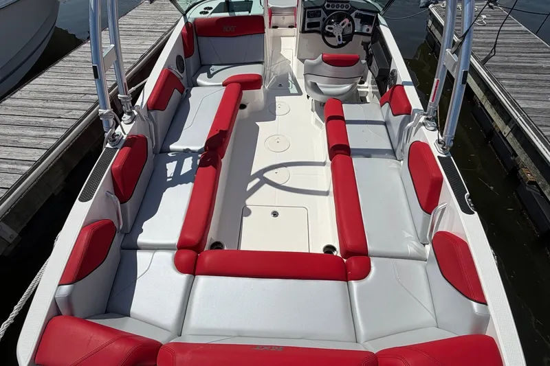 Slide: The Image of 2017 MasterCraft NXT20 Global Edition boat with red and white seating, docked at a marina. - 8