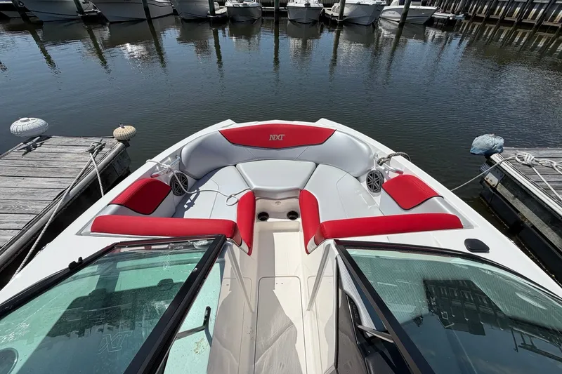 Slide: The Image of 2017 MasterCraft NXT20 Global Edition boat with red and gray seating at a marina. - 13