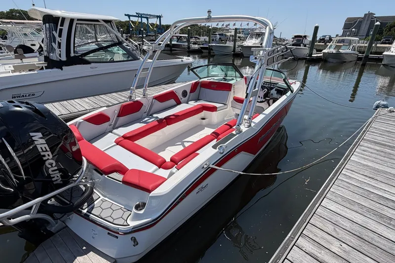 Slide: The Image of 2017 MasterCraft NXT20 Global Edition boat docked, featuring red and white seating, and a Mercury engine. - 4