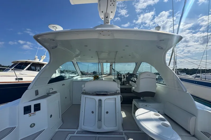 Slide: The Image of 2009 Cruisers Yachts 390 Sports Coupe interior with helm and seating, docked under blue sky. - 13