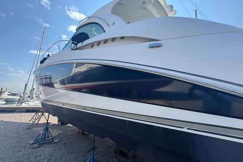 Slide: The Image of 2009 Cruisers Yachts 390 Sports Coupe on stands at marina, clear sky background. - 5