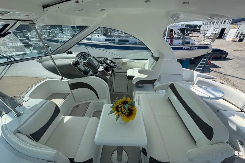 Slide: The Image of 2009 Cruisers Yachts 390 Sports Coupe interior with white seating and sunflowers on table. - 15