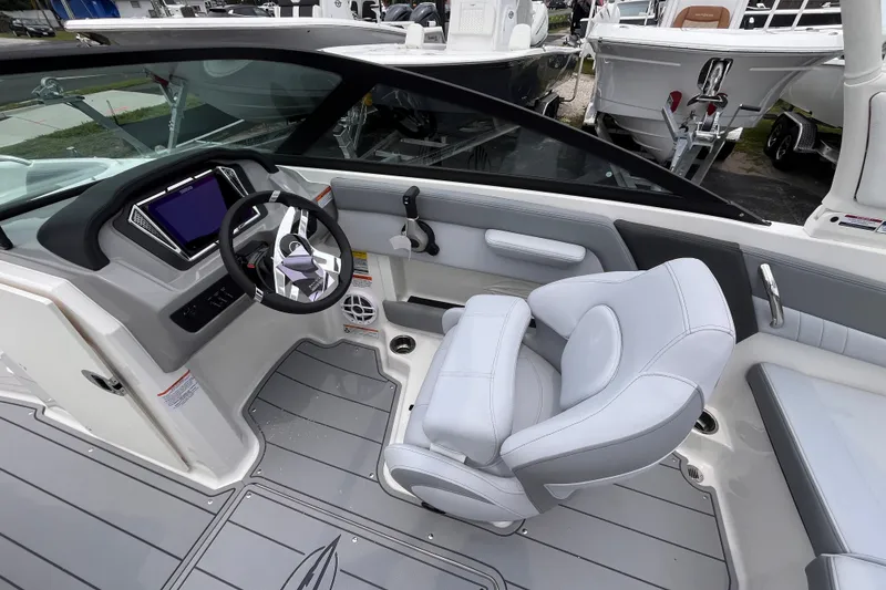 Slide: The Image of Interior view of 2027 Chaparral 21 SSi OB boat, featuring modern steering and seating. - 13