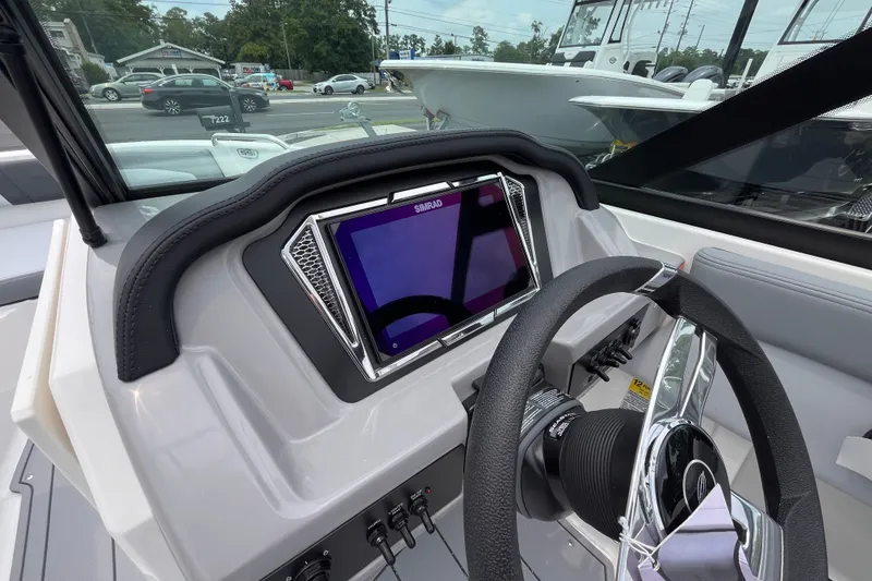 Slide: The Image of 2027 Chaparral 21 SSi OB boat dashboard with steering wheel and digital display. - 12