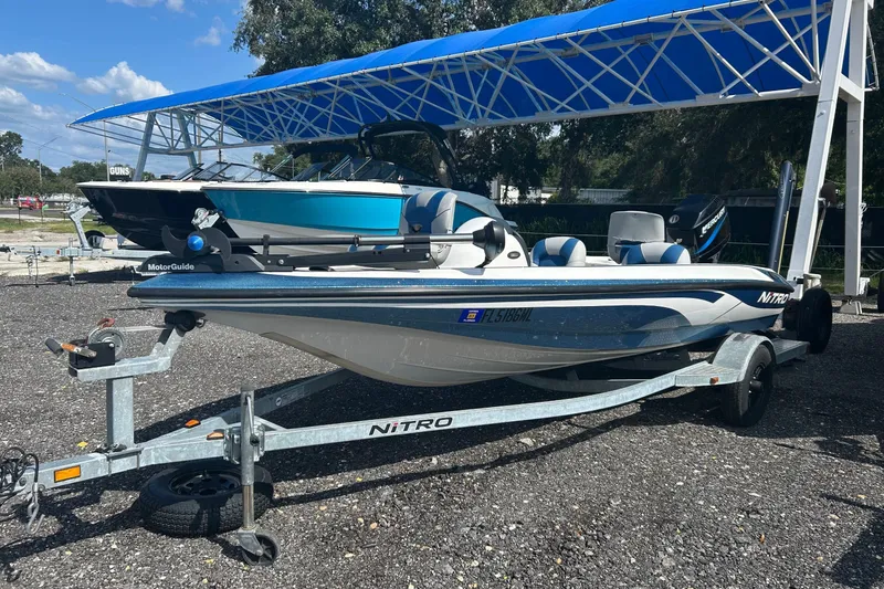 The Image of 2004 Nitro 700 LX SC boat on trailer under blue canopy. - 1