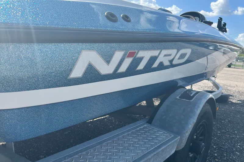 Slide: The Image of 2004 Nitro 700 LX SC boat on trailer, featuring metallic blue finish under sunny sky. - 6