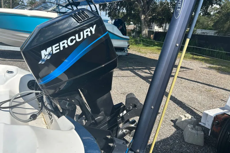 Slide: The Image of 2004 Nitro 700 LX SC boat with Mercury outboard motor in a parking area. - 13