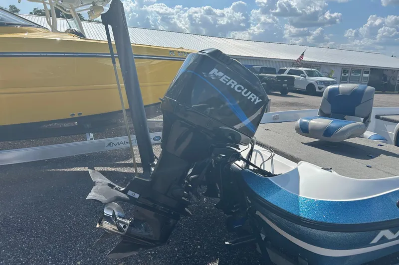 Slide: The Image of 2004 Nitro 700 LX SC boat with Mercury outboard motor, parked outdoors under a cloudy sky. - 14