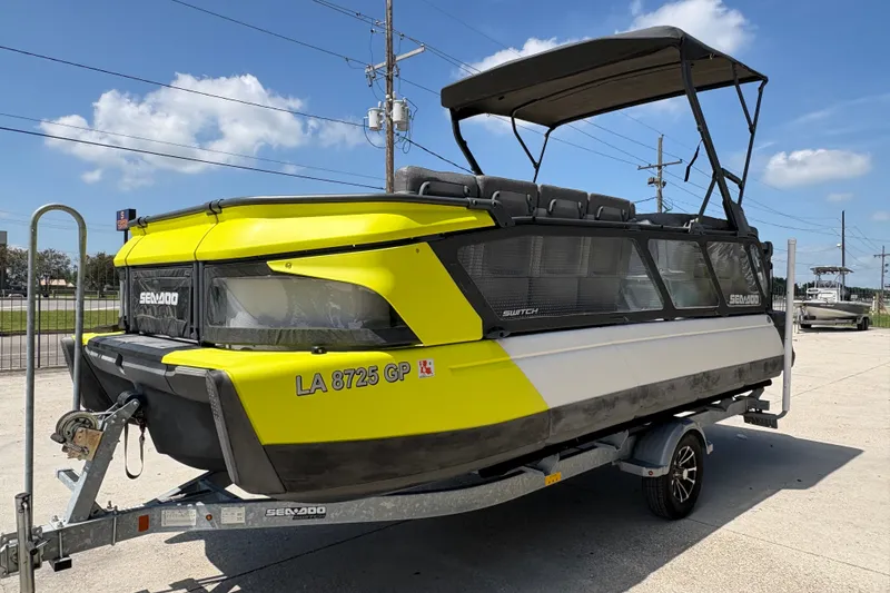 Slide: The Image of 2023 Seadoo Switch 21 boat on trailer, vibrant yellow and black design, parked outdoors. - 8