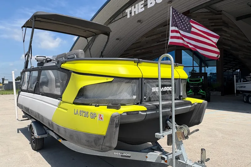 Slide: The Image of 2023 Seadoo Switch 21 pontoon boat with American flag, parked on trailer. - 10