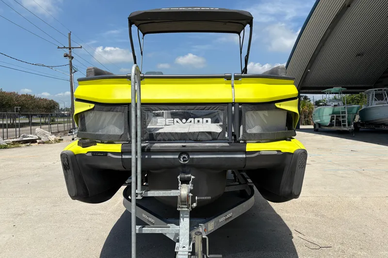Slide: The Image of 2023 Seadoo Switch 21 on trailer, vibrant yellow, parked outdoors under clear sky. - 9