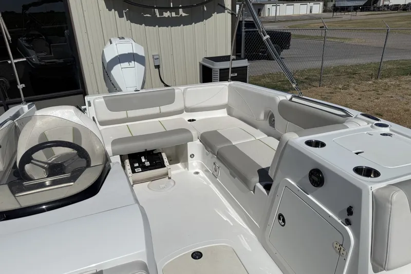 Slide: The Image of 2021 Tahoe 2150 boat interior with seating and steering wheel, parked outdoors. - 9