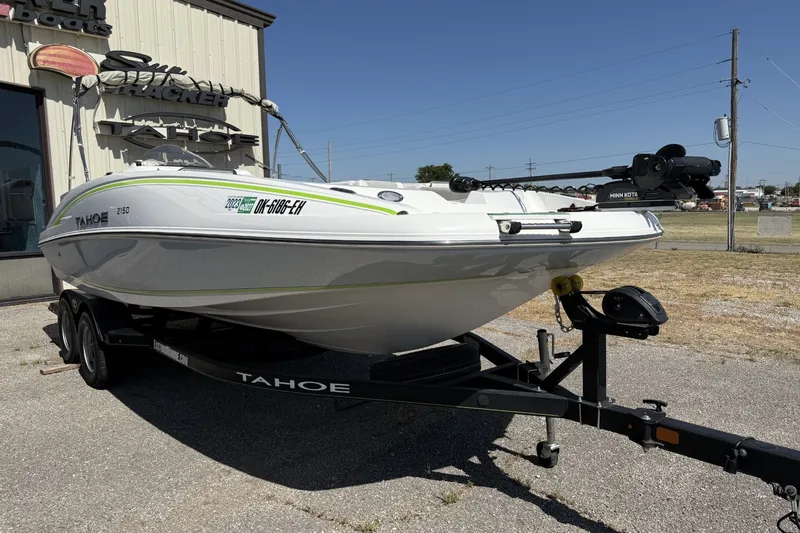 Slide: The Image of 2021 Tahoe 2150 boat on trailer, parked outdoors near a building. - 1