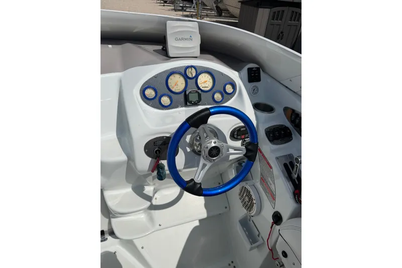 Slide: The Image of 2004 Baja 245 Performance boat cockpit with blue steering wheel and Garmin GPS. - 11