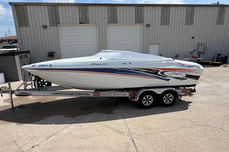 Slide: The Image of 2004 Baja 245 Performance boat on trailer, parked outside a warehouse. - 4