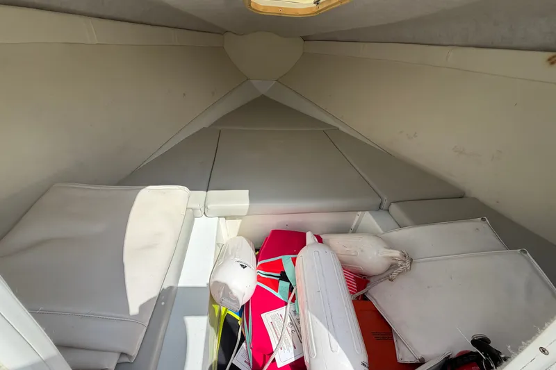 Slide: The Image of Interior cabin of a 2004 Baja 245 Performance boat with cushions and boating gear. - 12