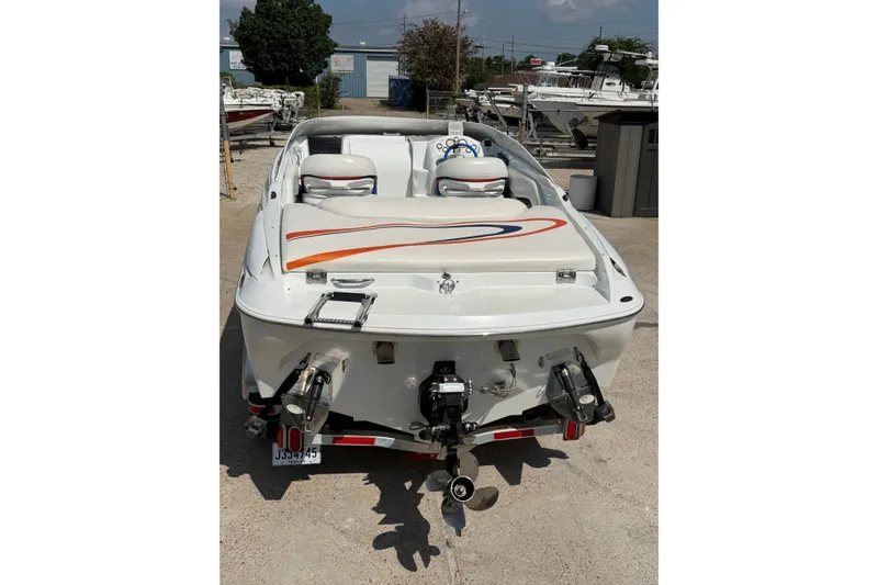 Slide: The Image of 2004 Baja 245 Performance boat, rear view, showcasing sleek design and dual propellers. - 6
