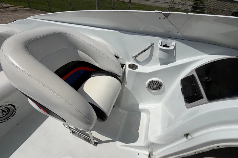 Slide: The Image of 2004 Baja 245 Performance boat interior with white and black seating, speaker, and control panel. - 16