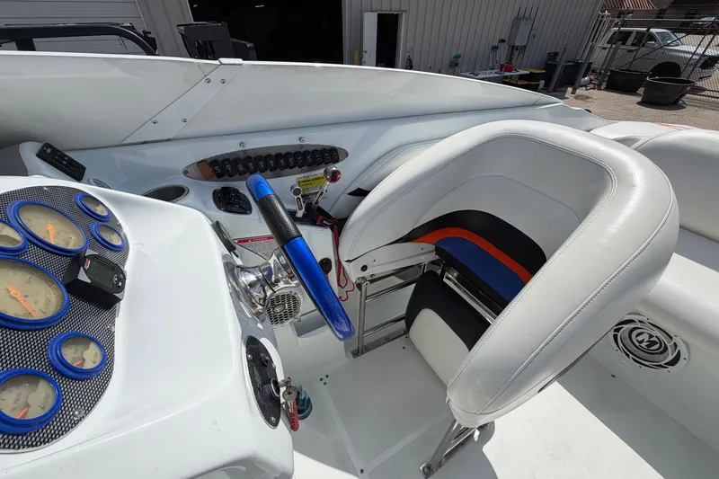 Slide: The Image of Interior of a 2004 Baja 245 Performance boat with gauges and steering wheel. - 15
