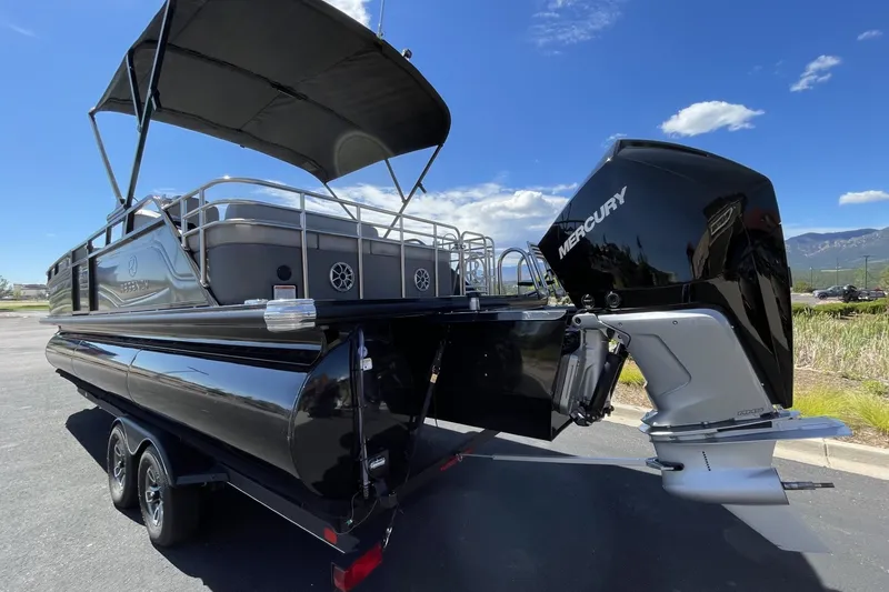 Slide: The Image of 2023 Regency 250LE pontoon boat with Mercury outboard motor, parked outdoors. - 3