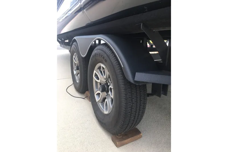 Slide: The Image of 2023 Regency 250LE trailer wheels on concrete with wooden block support. - 9