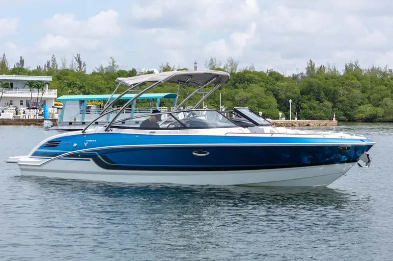 Slide: The Image of 2019 Formula 270 Bowrider boat on calm water, surrounded by lush greenery. - 5