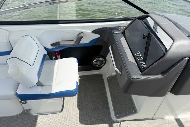Slide: The Image of 2019 Formula 270 Bowrider interior with white and blue seating, dashboard, and speaker. - 18