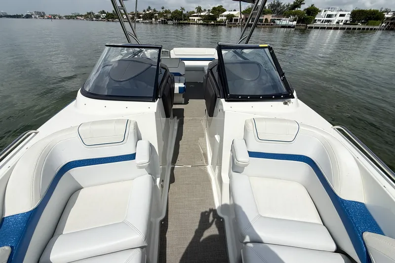 Slide: The Image of 2019 Formula 270 Bowrider boat interior with white and blue seating on calm water. - 13