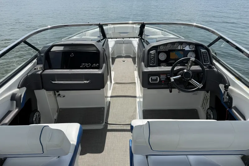 Slide: The Image of 2019 Formula 270 Bowrider interior with steering wheel and dashboard, on calm water. - 8