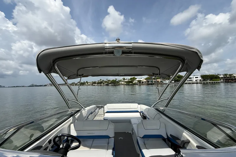 Slide: The Image of 2019 Formula 270 Bowrider boat with canopy on calm water under cloudy sky. - 9