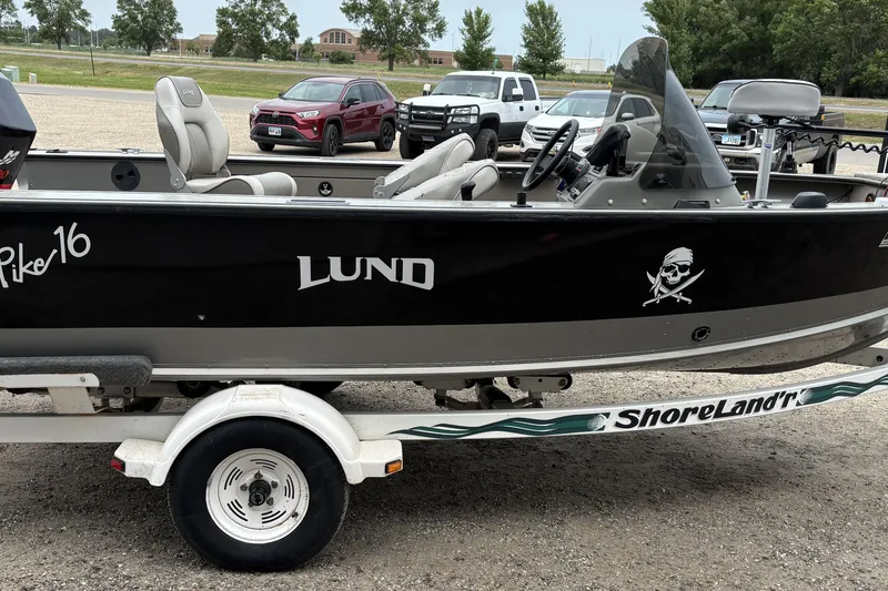 Slide: The Image of 2001 Lund Mr. Pike 16 boat on ShoreLand'r trailer, parked with vehicles in the background. - 2