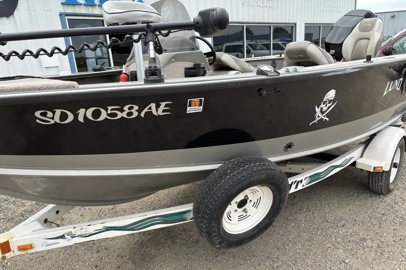 Slide: The Image of 2001 Lund Mr. Pike 16 boat on trailer, black with pirate decal and registration SD1058AE. - 6