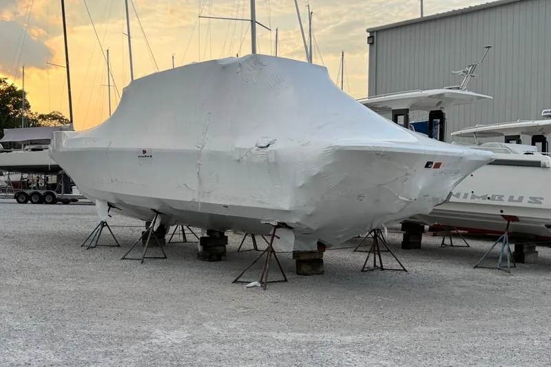 Slide: The Image of 2026 Nimbus Weekender 11 boat covered in protective wrap at a marina during sunset. - 5