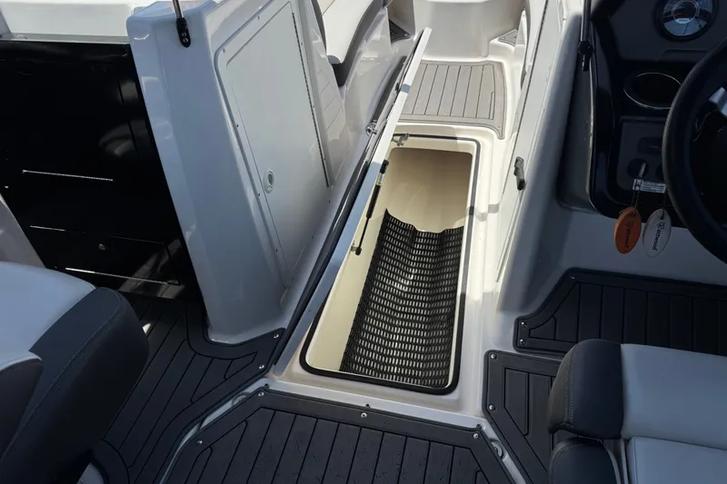 Slide: The Image of 2017 Yamaha Boats 212 Limited interior storage compartment with open hatch and sleek design. - 25