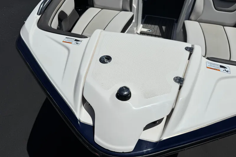 Slide: The Image of 2017 Yamaha Boats 212 Limited bow seating area with white upholstery and storage compartment. - 12
