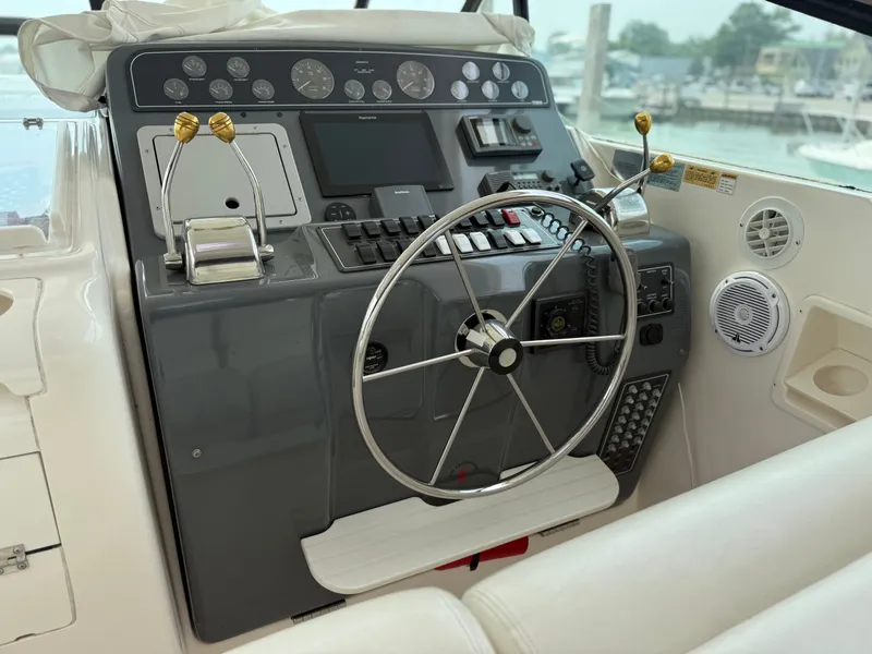 Slide: The Image of The image shows the helm of a 1999 Tiara Yachts 4000 Express with a large steering wheel and various instruments. - 16