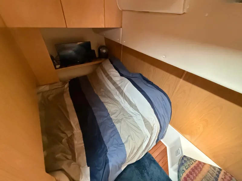 Slide: The Image of The 1999 Tiara Yachts 4000 Express cabin features a cozy bed and wooden furnishings. - 38