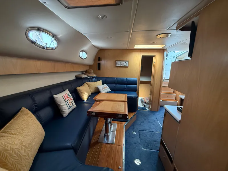 Slide: The Image of Interior of a 1999 Tiara Yachts 4000 Express with blue upholstery and a wooden table. - 25