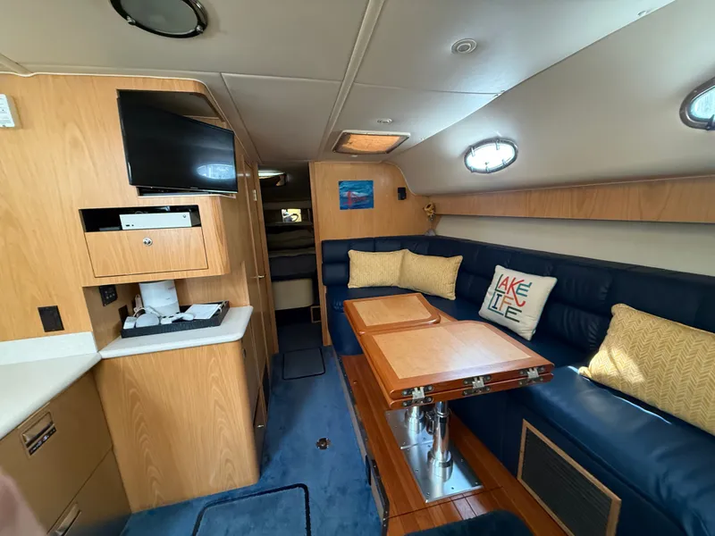 Slide: The Image of Interior of a 1999 Tiara Yachts 4000 Express with blue upholstery and a wooden table. - 22