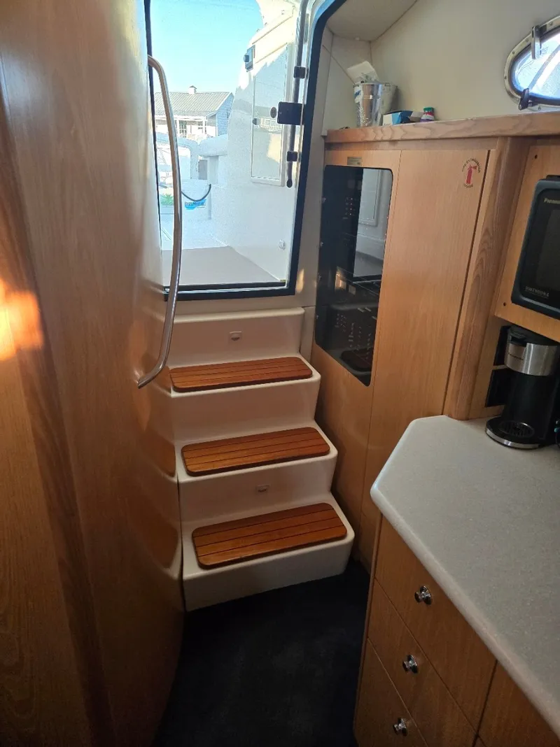 Slide: The Image of The cabin stairs of the 1999 Tiara Yachts 4000 Express lead outside. - 27
