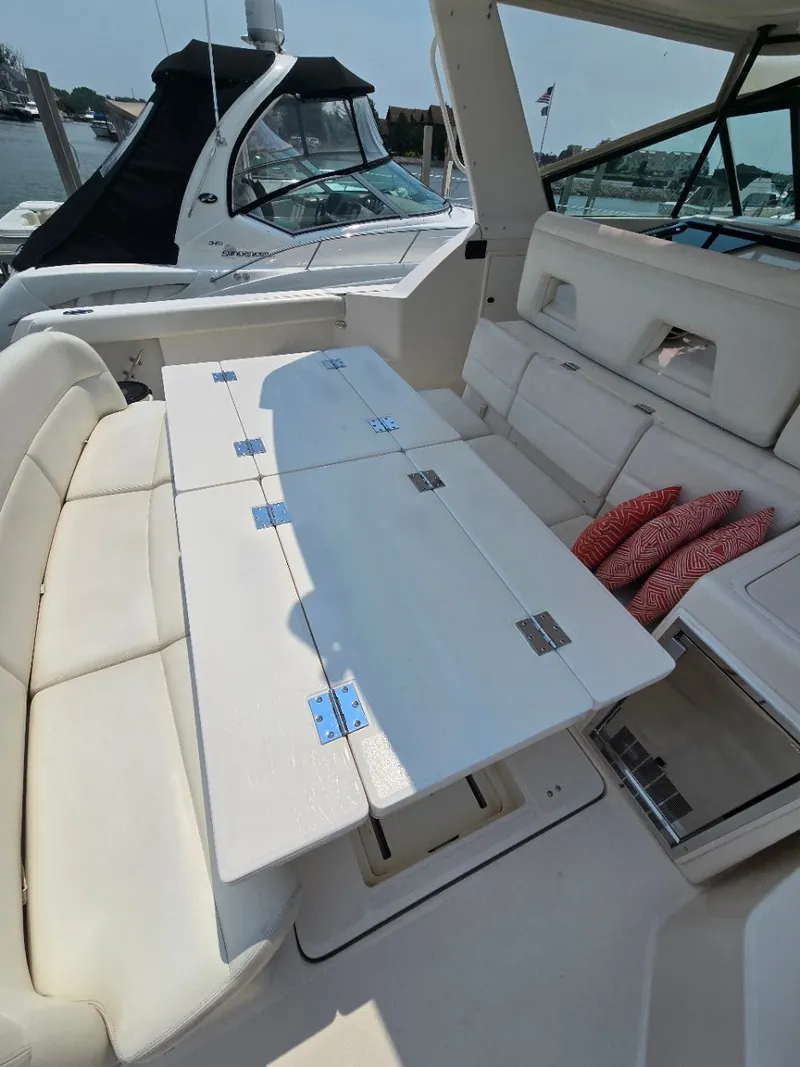 Slide: The Image of The image shows the seating area of a 1999 Tiara Yachts 4000 Express with a folding table. - 12