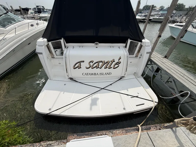 Slide: The Image of The stern of a 1999 Tiara Yachts 4000 Express, docked at a pier. - 4