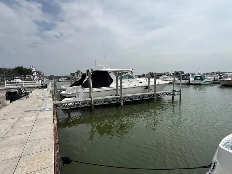 Slide: The Image of A 1999 Tiara Yachts 4000 Express docked in a calm harbor setting. - 7