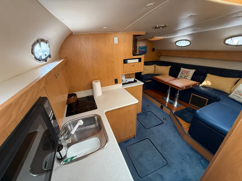 Slide: The Image of Interior of a 1999 Tiara Yachts 4000 Express with kitchen, seating area, and wooden furnishings. - 19
