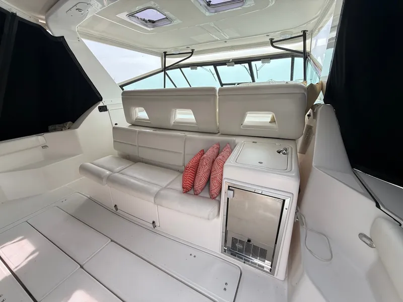 Slide: The Image of The image shows the cockpit of a 1999 Tiara Yachts 4000 Express with white seating and red cushions. - 13