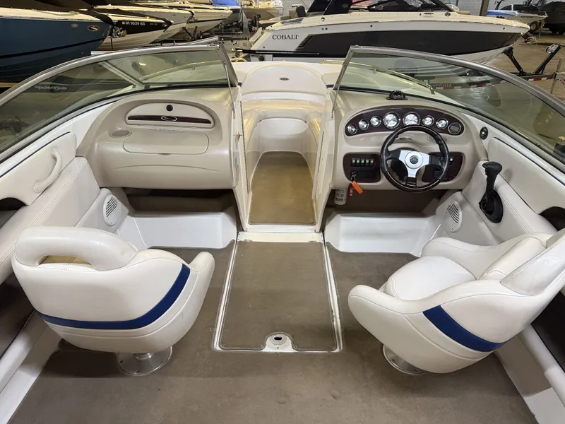 Slide: The Image of The image shows the cockpit of a 2001 Chaparral 219 boat with white seats and a helm. - 18