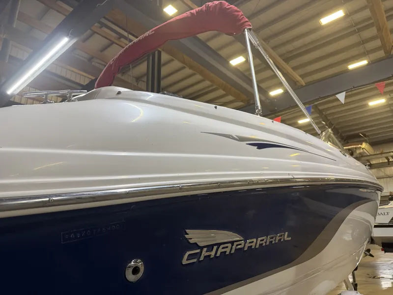 Slide: The Image of A 2001 Chaparral 219 boat in a warehouse. It features a white and blue exterior. - 11