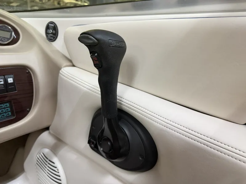 Slide: The Image of Close-up of a black throttle lever in a 2001 Chaparral 219 boat, surrounded by beige interior. - 36