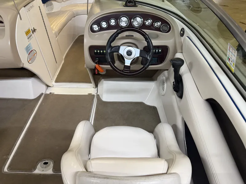 Slide: The Image of The image shows the cockpit of a 2001 Chaparral 219 boat with a white seat and a dashboard featuring multiple gauges. - 25