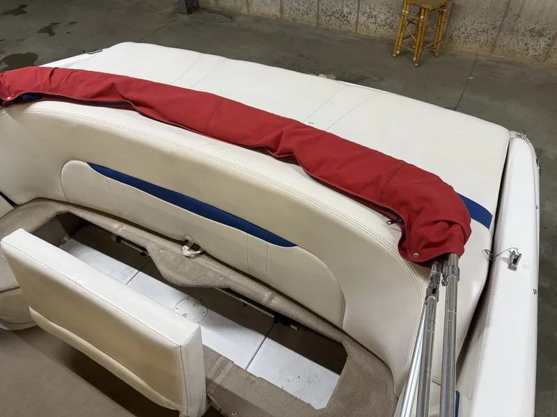 Slide: The Image of A white boat with red and blue accents. It features a padded bench seat and a red cover. - 17